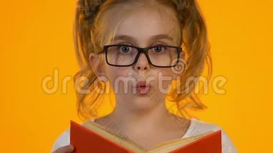 小聪明的孩子在眼镜阅读百科全书震惊有趣的事实